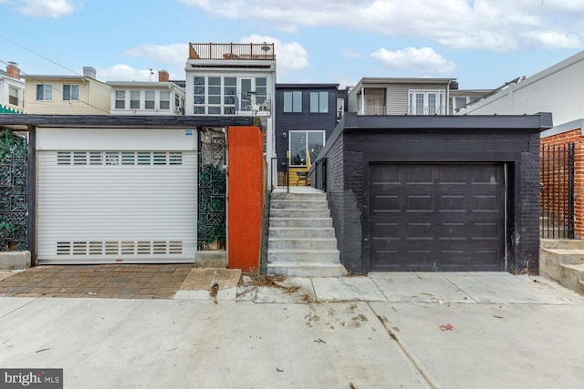 view of front of home featuring driveway and a balcony