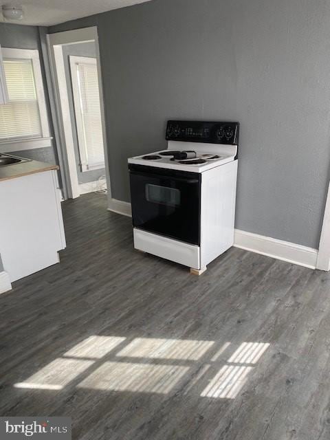 kitchen featuring dark wood-type flooring and range with electric cooktop