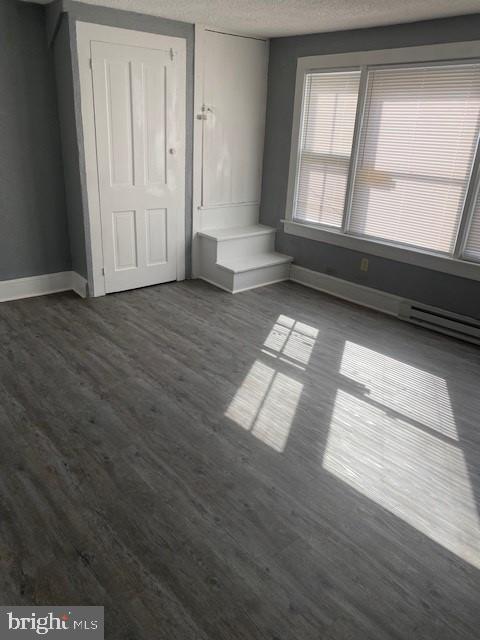 unfurnished bedroom featuring dark wood-type flooring and a textured ceiling