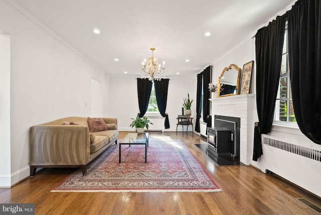 living area featuring radiator heating unit, ornamental molding, wood finished floors, a chandelier, and recessed lighting