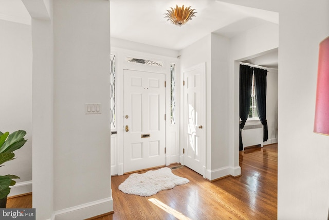 foyer entrance with wood finished floors and baseboards