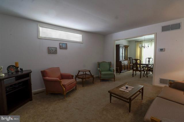 living room with carpet flooring and a notable chandelier