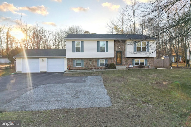 bi-level home with a garage and a lawn