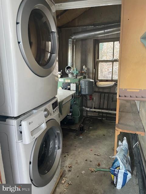 washroom featuring stacked washer and clothes dryer