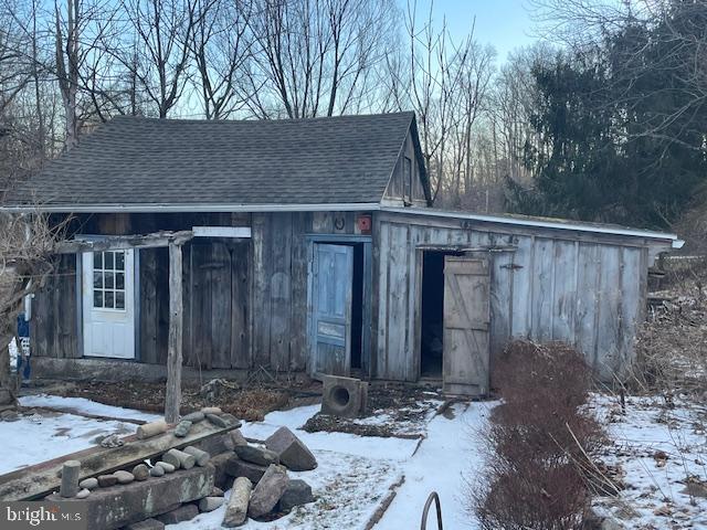 snow covered structure featuring ac unit