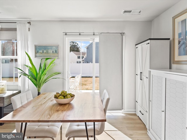 dining space featuring visible vents and light wood finished floors