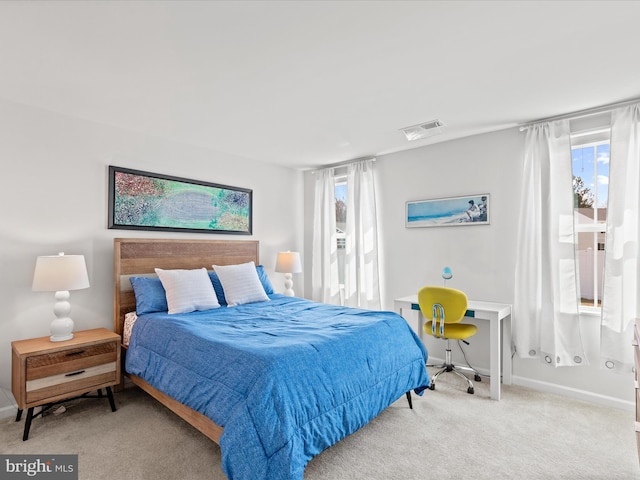 carpeted bedroom with visible vents, multiple windows, and baseboards