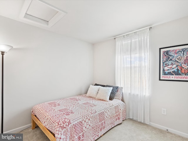 carpeted bedroom with baseboards and attic access