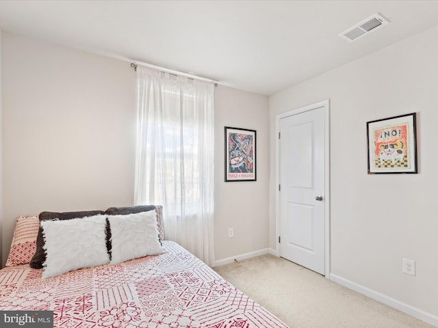 bedroom featuring light carpet, visible vents, and baseboards