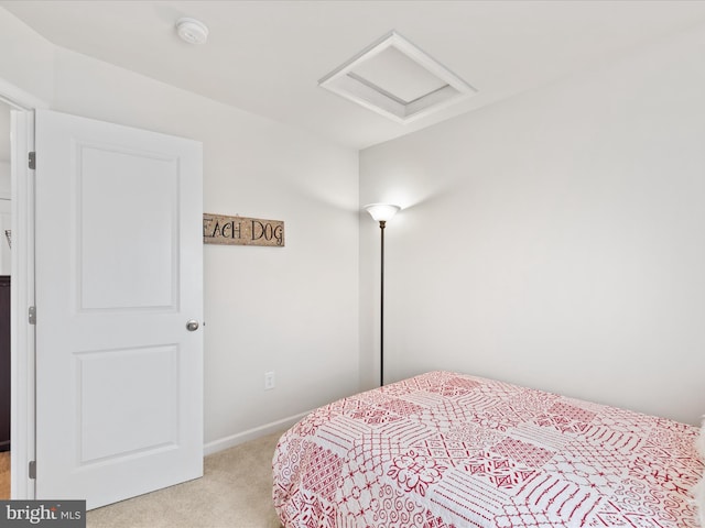 bedroom with baseboards, light carpet, and attic access