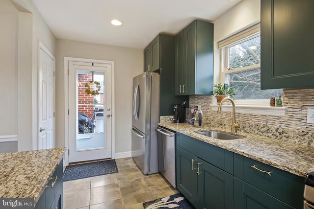 kitchen with stainless steel appliances, decorative backsplash, a sink, and light stone countertops