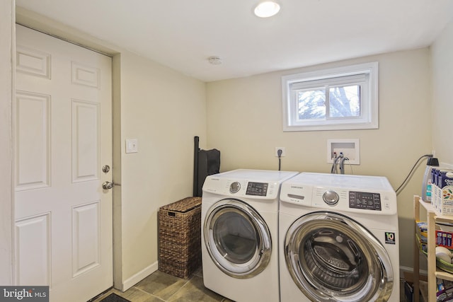 laundry area with laundry area, washer and clothes dryer, and baseboards