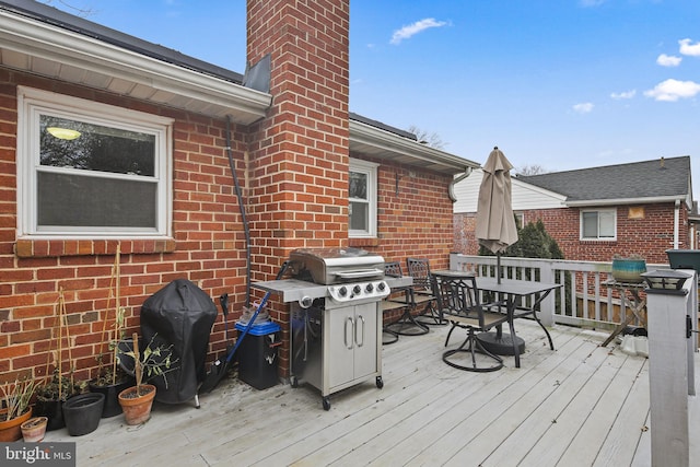 deck featuring outdoor dining space and a grill