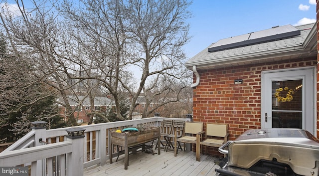 wooden deck featuring outdoor dining space and a grill