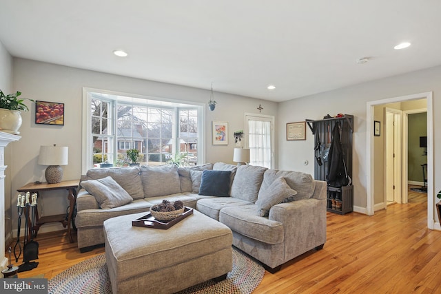 living area with baseboards, recessed lighting, and light wood-style floors