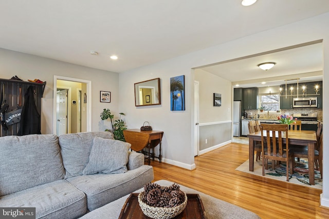 living area featuring light wood-style floors, recessed lighting, and baseboards