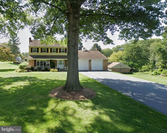 view of front of property with a front lawn, driveway, and an attached garage