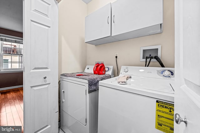 laundry room featuring cabinets, washer and clothes dryer, and hardwood / wood-style floors