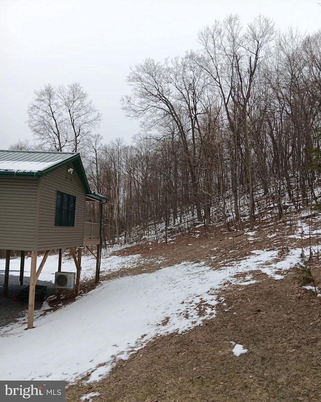 snowy yard featuring ac unit