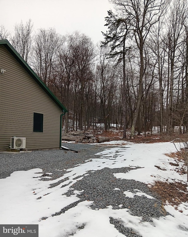 snowy yard featuring ac unit