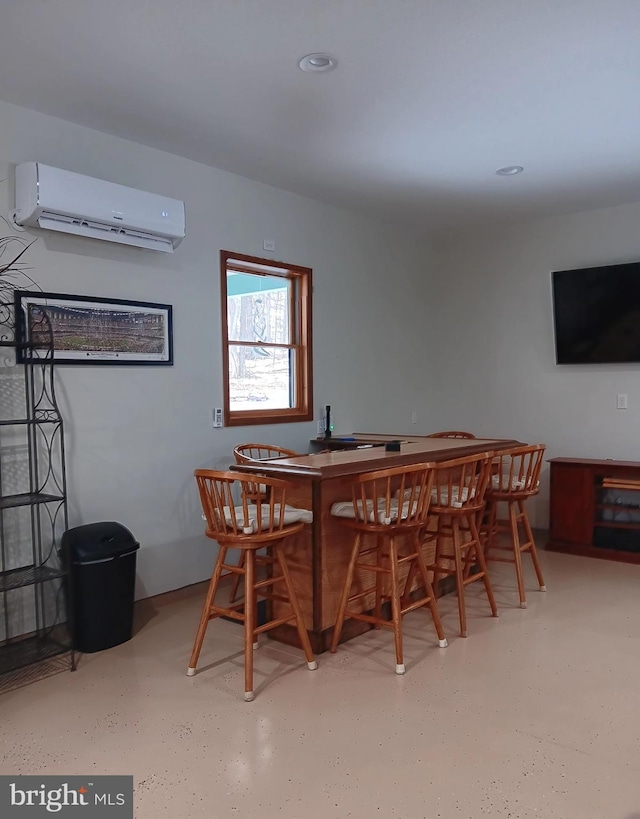 dining area featuring bar area and a wall mounted AC