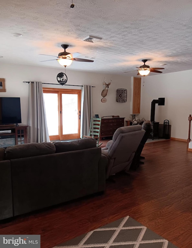 living area with dark wood-style floors, ceiling fan, and a textured ceiling