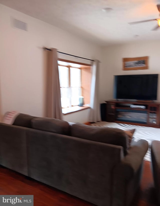 living area with dark wood-style flooring and a ceiling fan