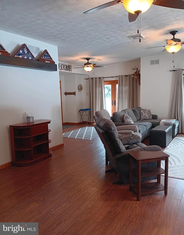 living room with visible vents, ceiling fan, a textured ceiling, and wood finished floors