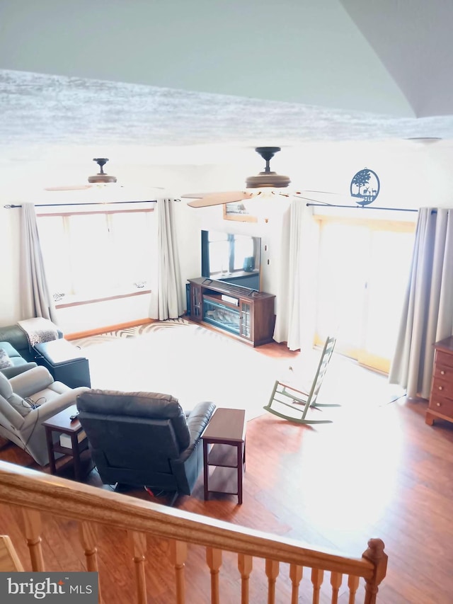 living area featuring a ceiling fan and wood finished floors