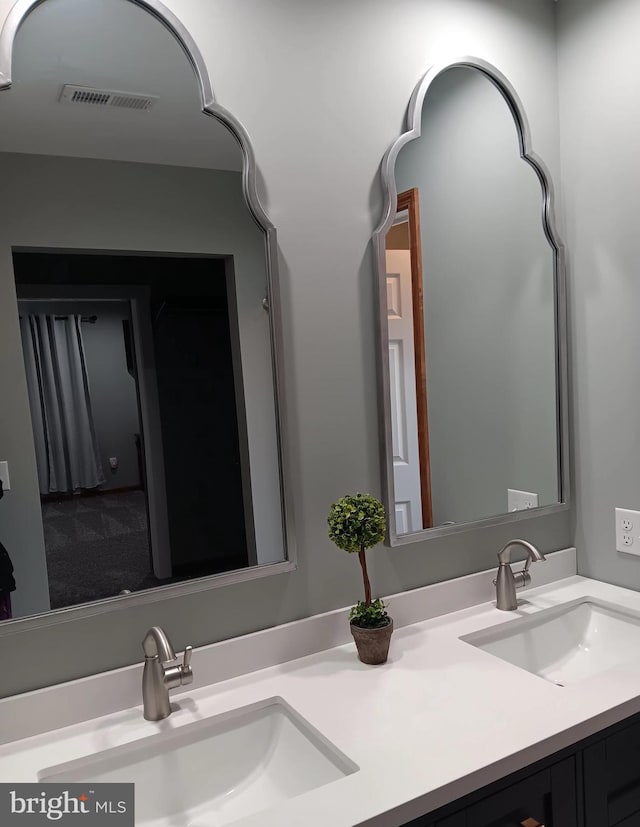 full bathroom featuring visible vents, a sink, and double vanity