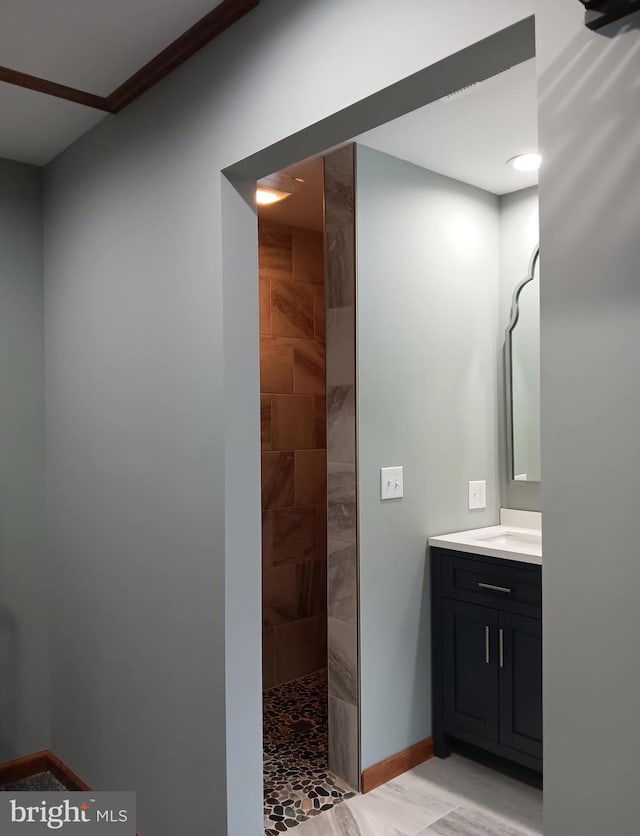 full bathroom with vanity, baseboards, and a walk in shower