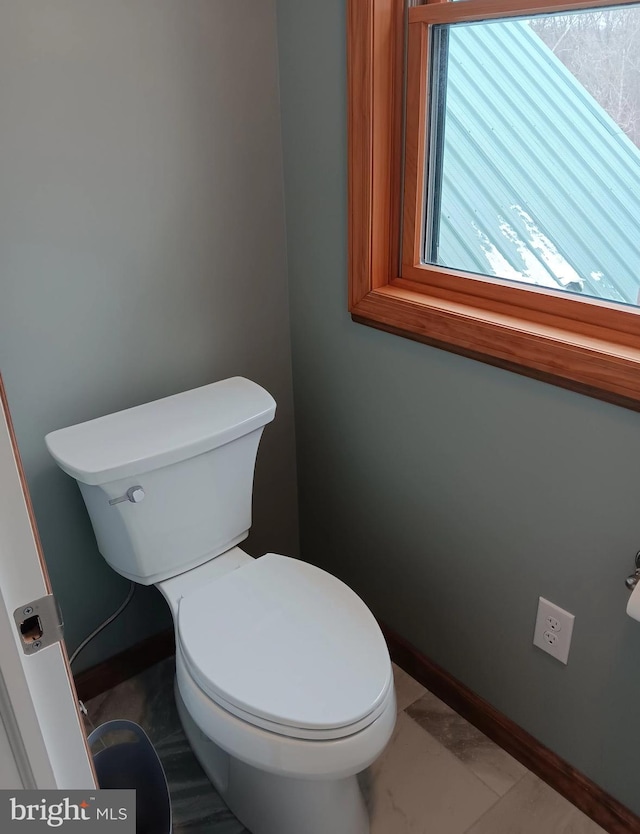 bathroom with toilet and baseboards