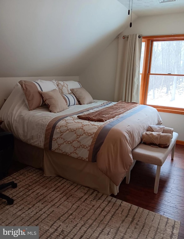 bedroom with visible vents, vaulted ceiling, and dark wood-type flooring