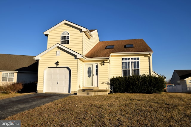 traditional home with driveway, a shingled roof, and a front lawn