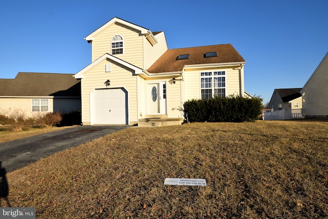 traditional home with a front yard, roof with shingles, and driveway