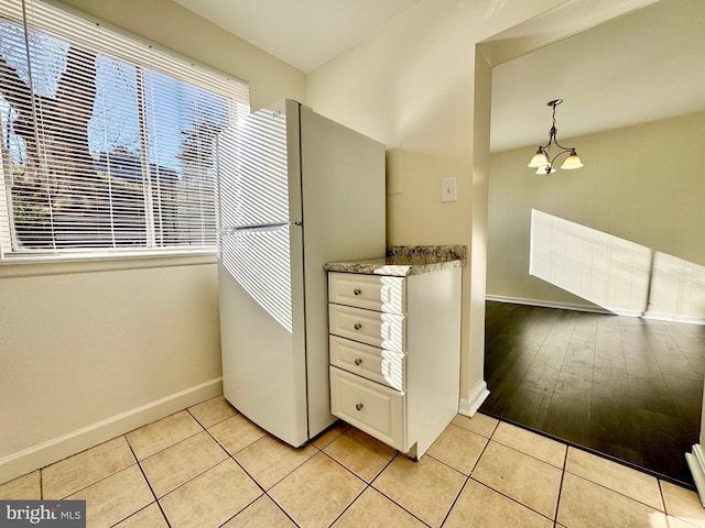 interior space with tile patterned flooring, baseboards, and an inviting chandelier