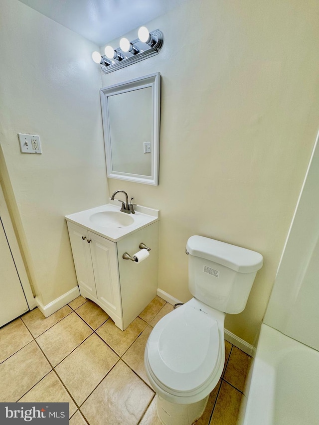 bathroom with tile patterned flooring, toilet, vanity, and baseboards