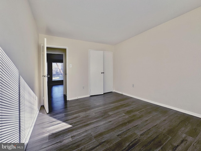 unfurnished bedroom featuring dark wood-type flooring and baseboards