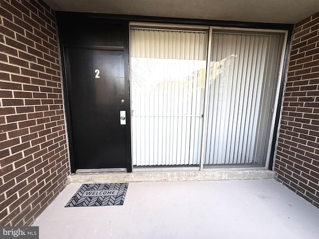 view of exterior entry with brick siding