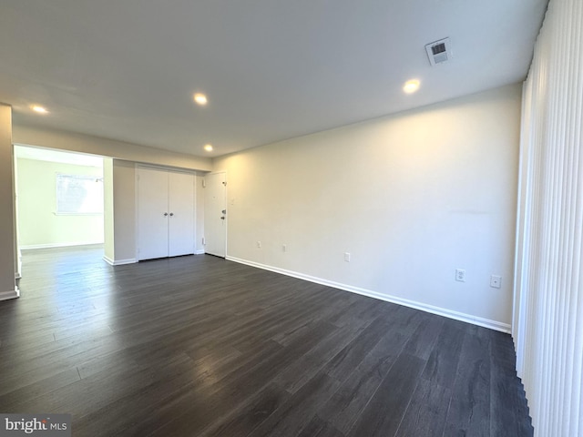 unfurnished room with recessed lighting, dark wood-style floors, visible vents, and baseboards