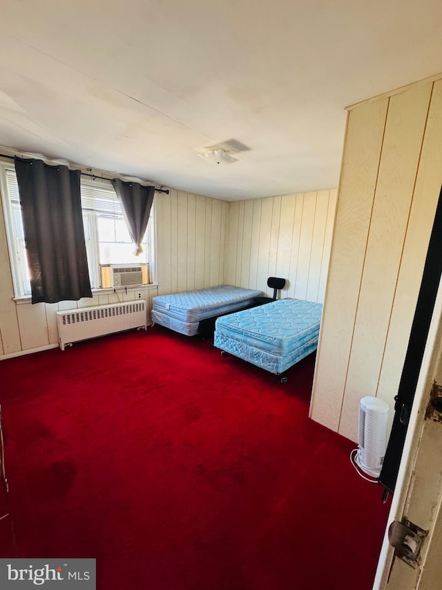 unfurnished bedroom with radiator heating unit, cooling unit, and carpet flooring