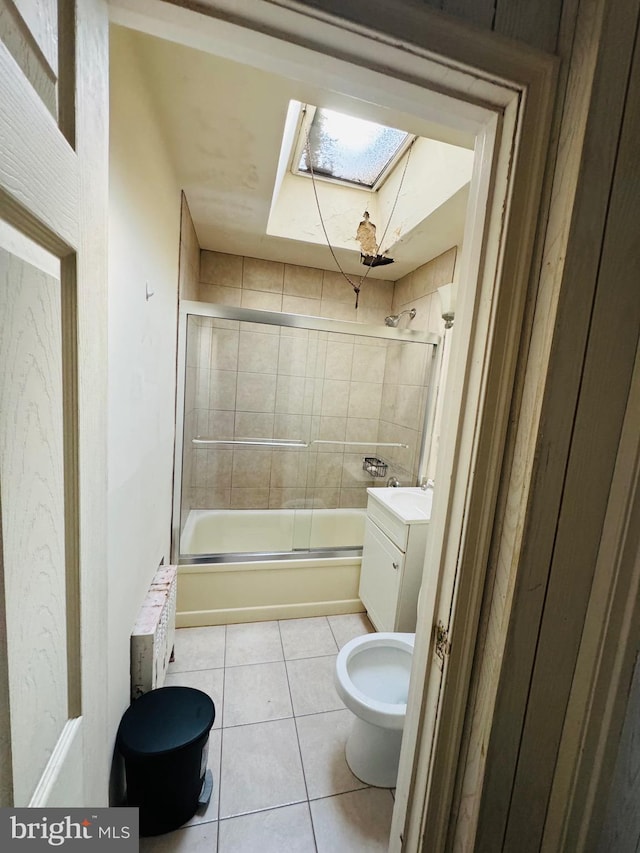 bathroom with enclosed tub / shower combo, a skylight, tile patterned flooring, and vanity