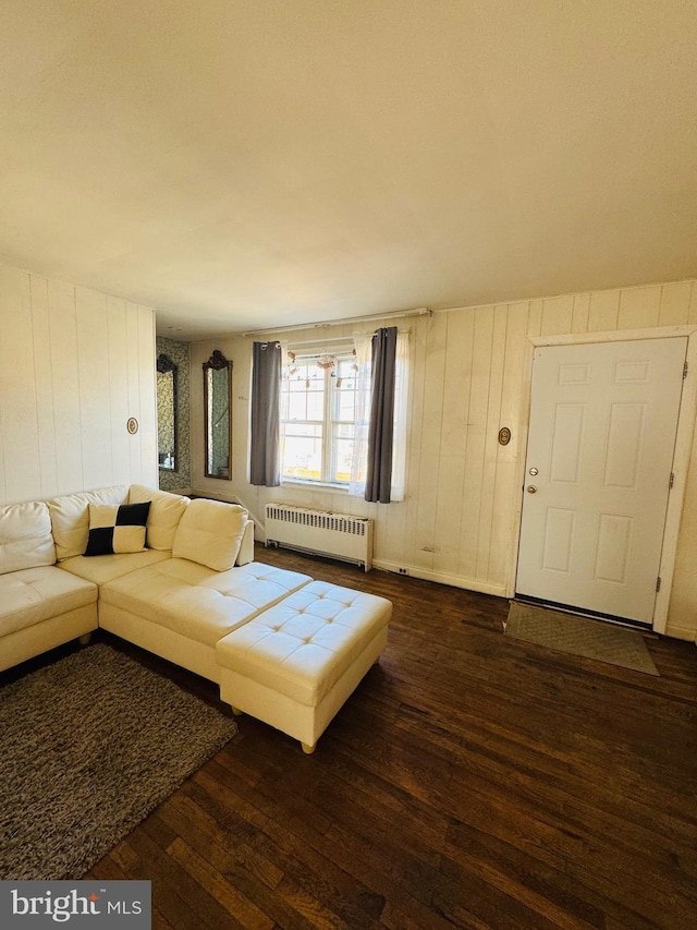 unfurnished living room featuring dark wood-style floors and radiator