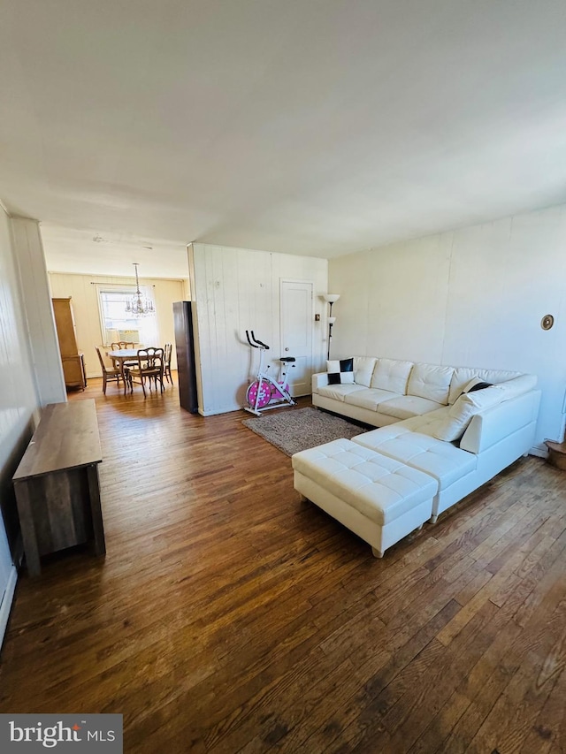 living area featuring dark wood-type flooring and a notable chandelier