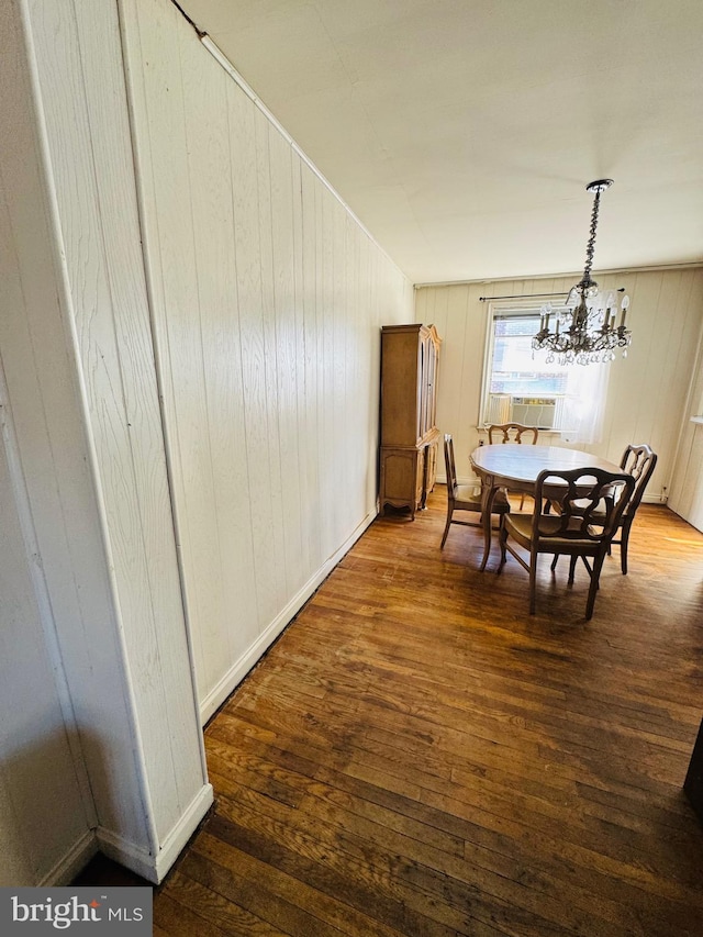 dining area with a chandelier, cooling unit, dark wood finished floors, and baseboards