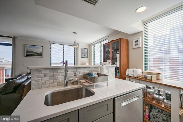 kitchen with hanging light fixtures, sink, a wealth of natural light, and gray cabinetry