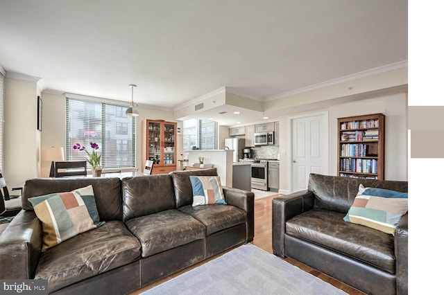 living room featuring crown molding and light hardwood / wood-style flooring