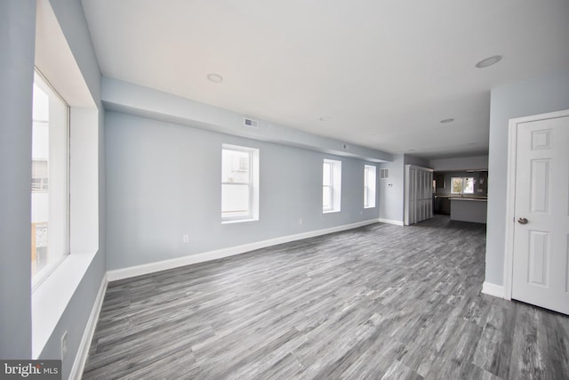 unfurnished living room featuring wood-type flooring and plenty of natural light