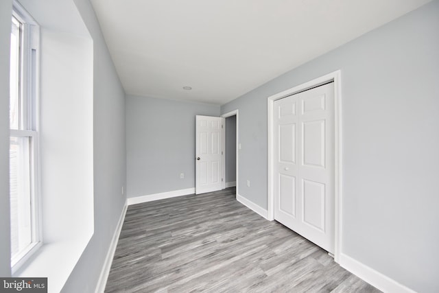 unfurnished bedroom featuring light hardwood / wood-style floors and a closet