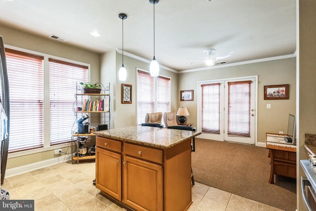 kitchen featuring visible vents, light stone counters, brown cabinets, hanging light fixtures, and a healthy amount of sunlight